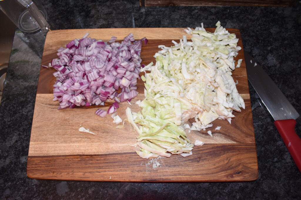 Chopped onions and cabbage on a cutting board