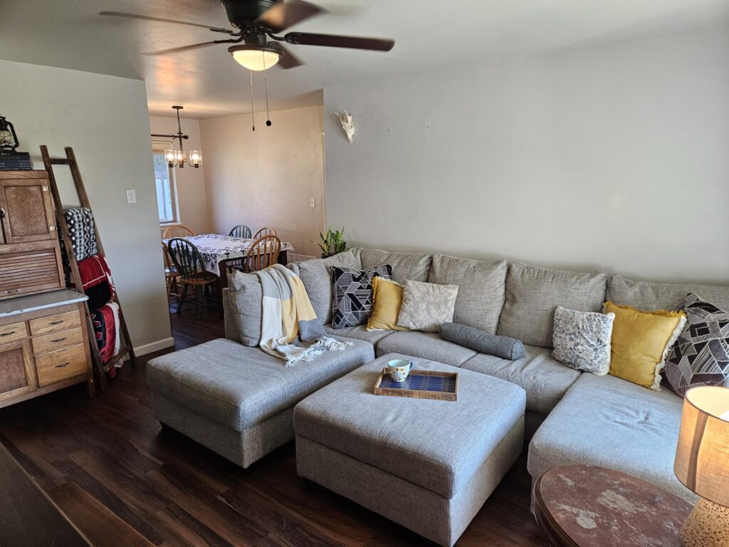 Living room couch with throw pillows and coffee mug tray