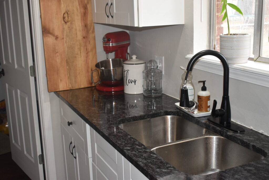 Clean kitchen counter with red stand mixer, cutting board, flour jar, and cookie jar