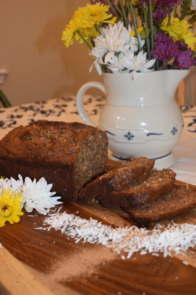 Banana Bread sliced on a cutting board with flowers