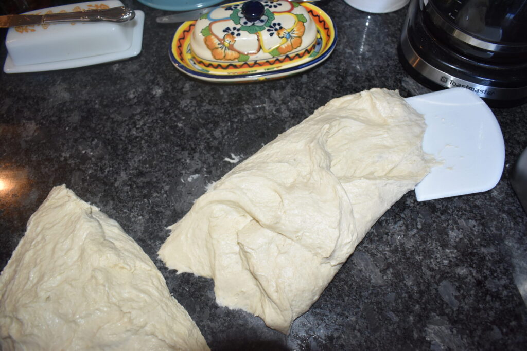 sourdough divided in two and one is stretched and folded in thirds