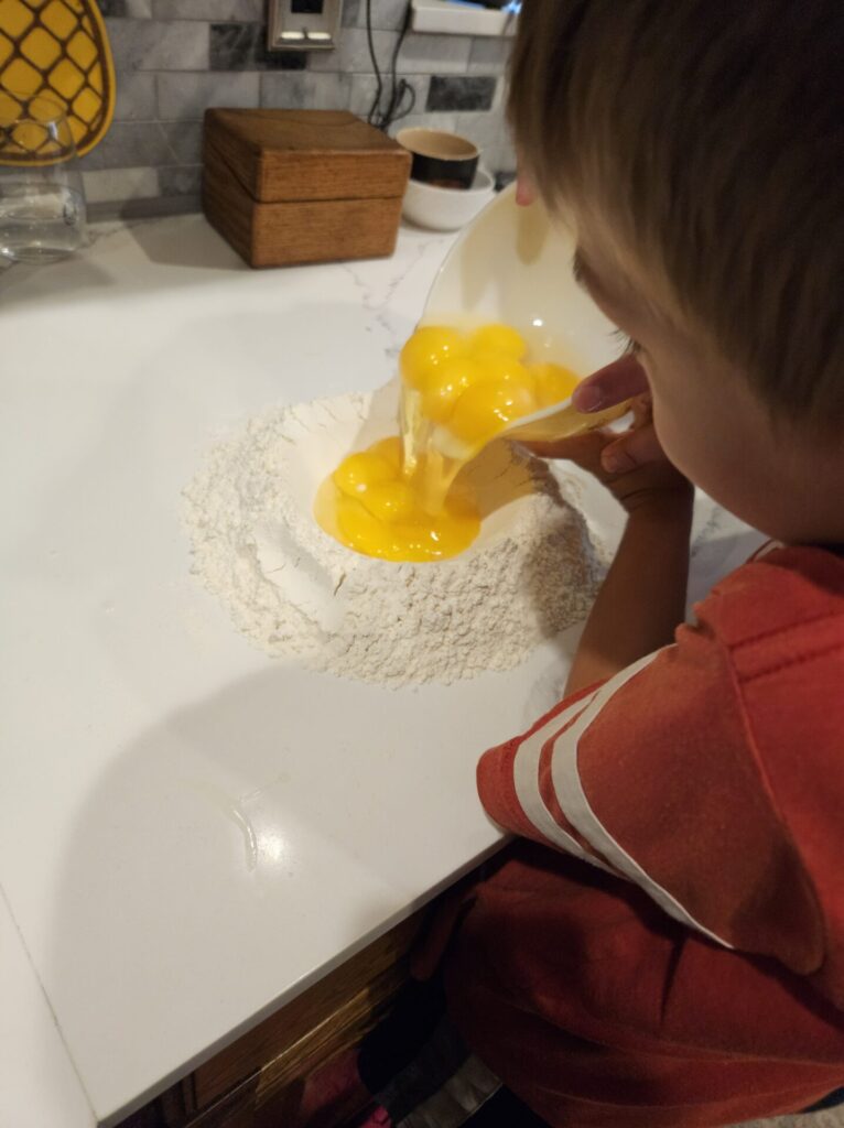 Pouring eggs into a flour well