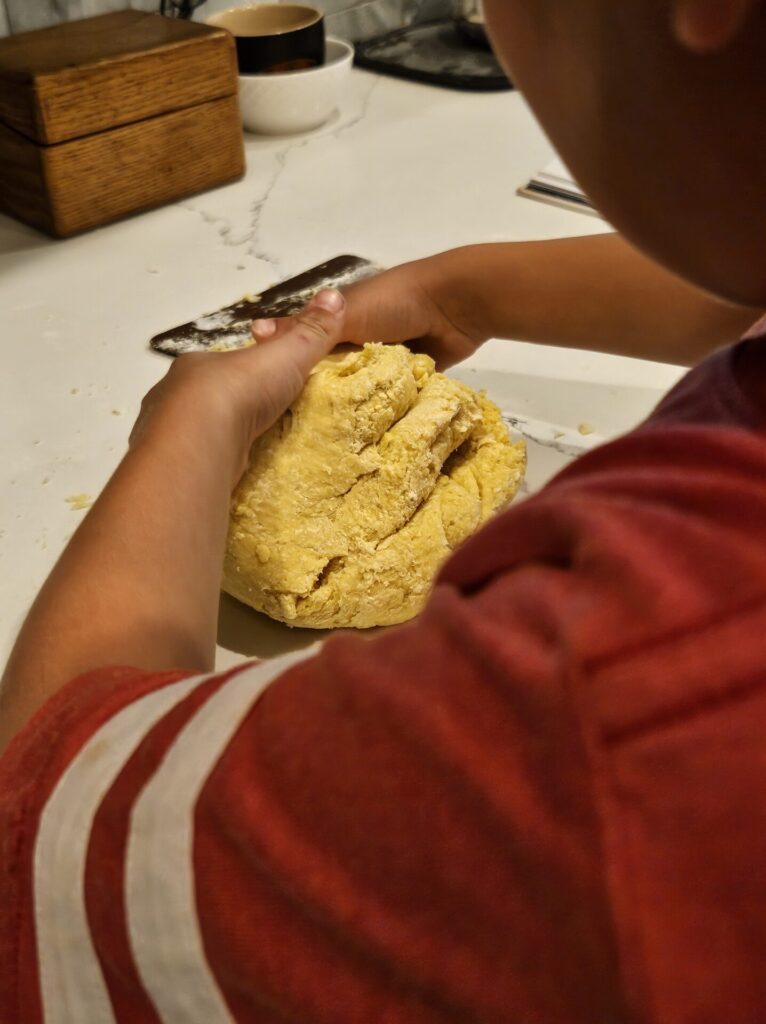 Young boy kneading a pasta dough
