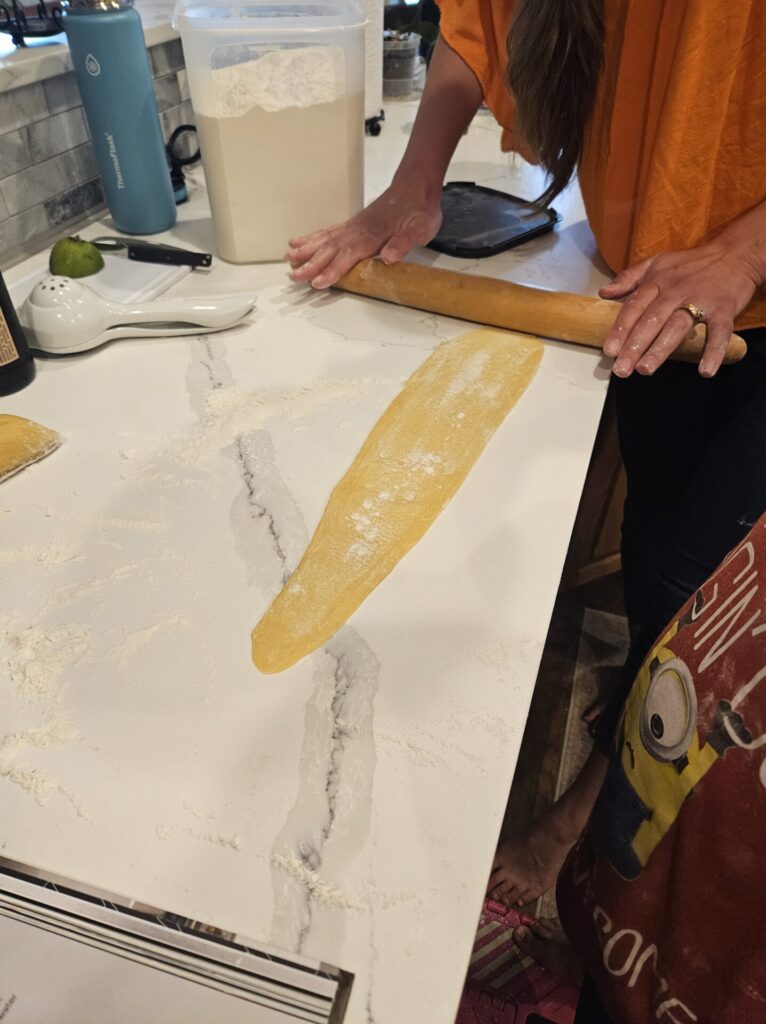 Woman rolling out pasta dough on the counter